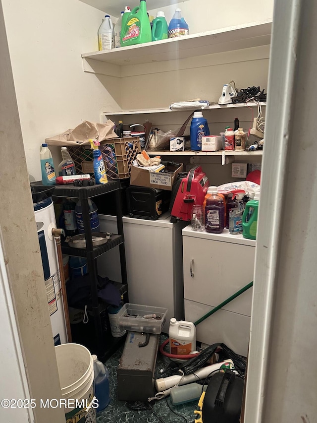 laundry room featuring water heater and washing machine and clothes dryer