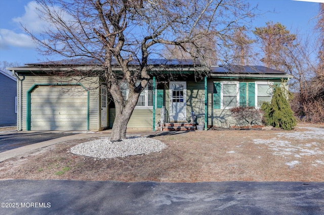 ranch-style home with solar panels and a garage