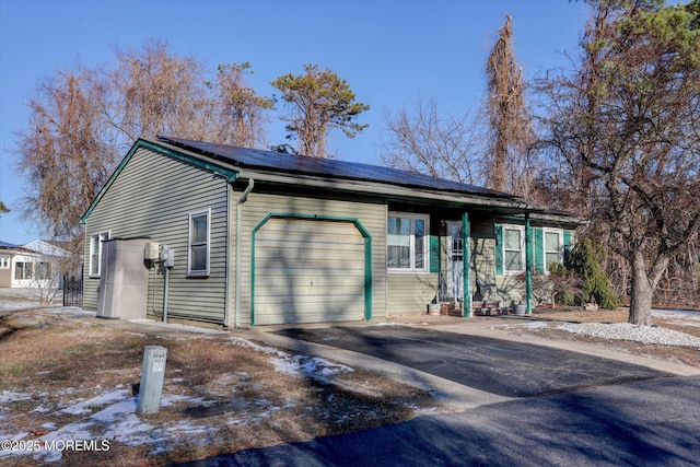 ranch-style home featuring solar panels and a garage