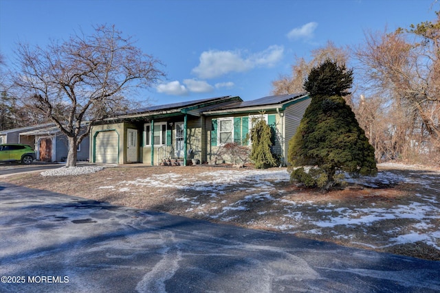 single story home with solar panels and a garage