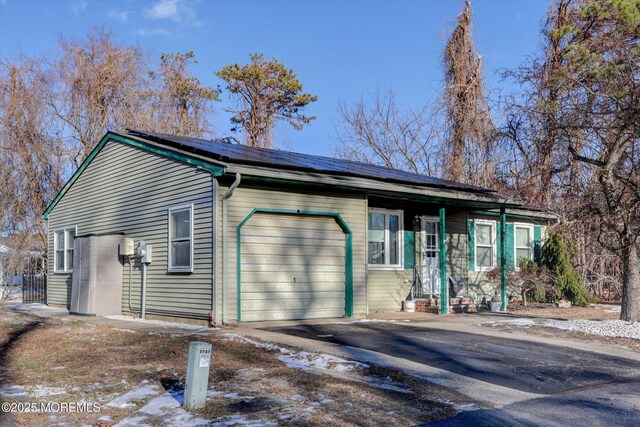 view of side of property with solar panels and a garage