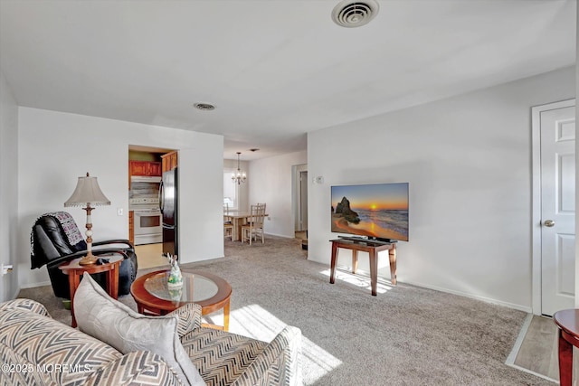 living room with light colored carpet and an inviting chandelier