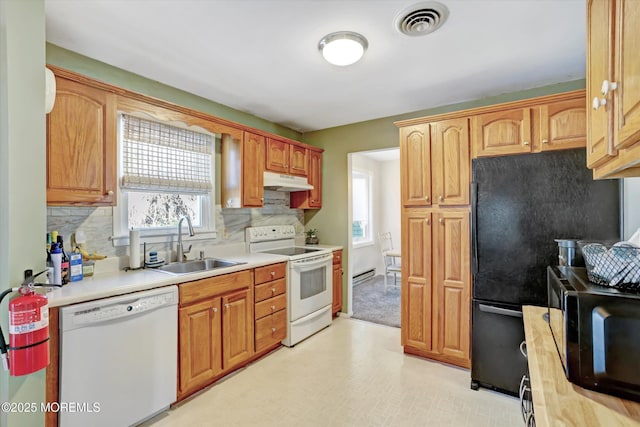 kitchen with white appliances, a baseboard radiator, backsplash, and sink