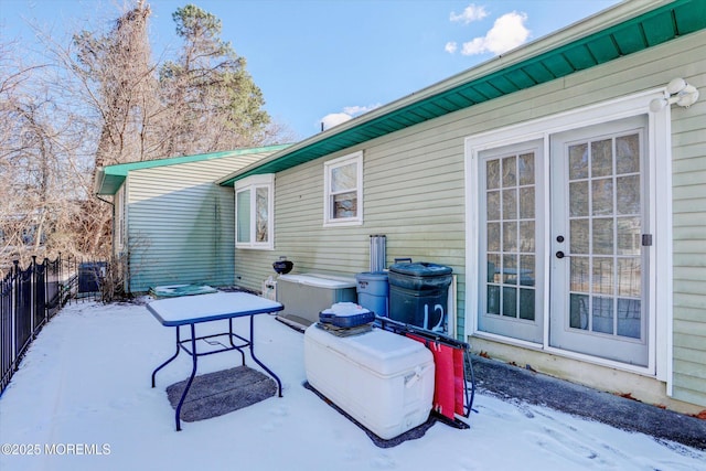 snow covered patio featuring french doors