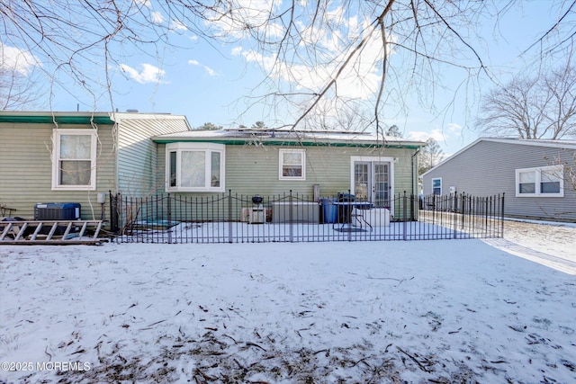 snow covered house featuring central air condition unit