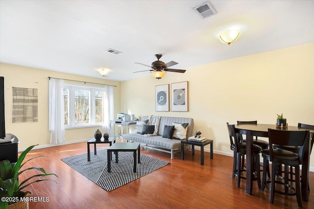 living room featuring ceiling fan and dark hardwood / wood-style floors