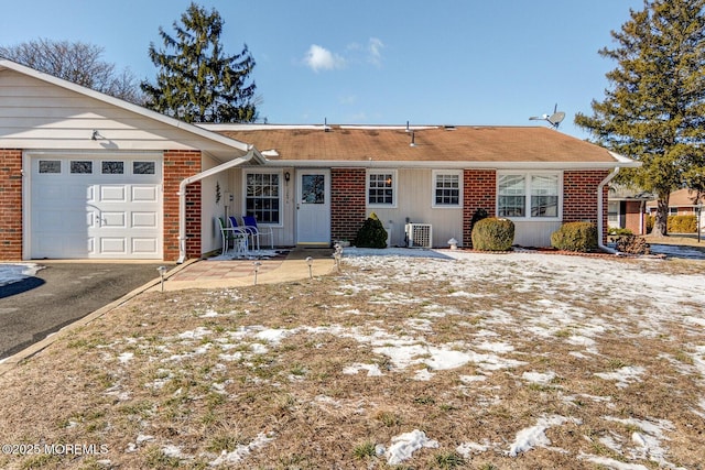 ranch-style house featuring a garage and central AC