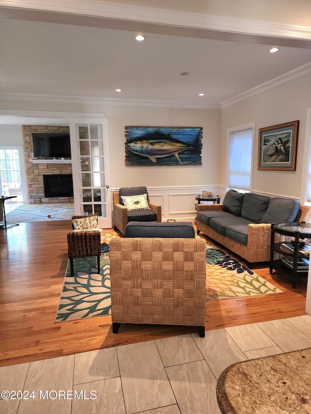 living room with crown molding, a fireplace, and light hardwood / wood-style floors