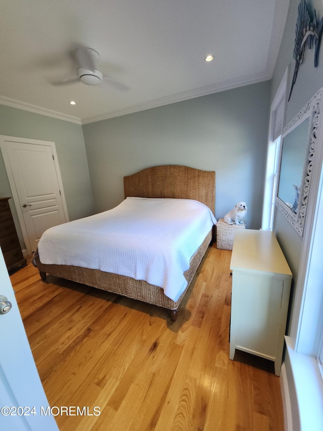 bedroom with ornamental molding, ceiling fan, and light hardwood / wood-style flooring