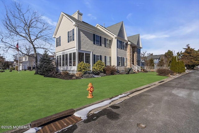 view of side of property with a lawn