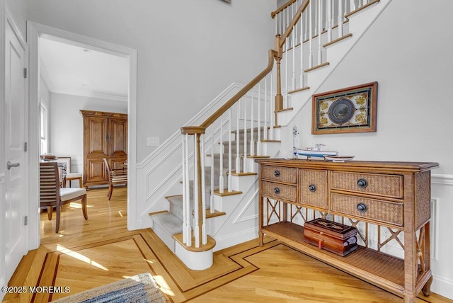 stairway featuring parquet floors and crown molding