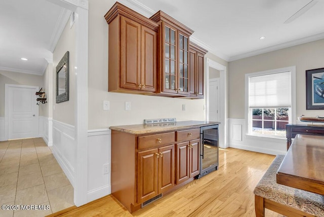 kitchen featuring wine cooler, crown molding, and light hardwood / wood-style flooring