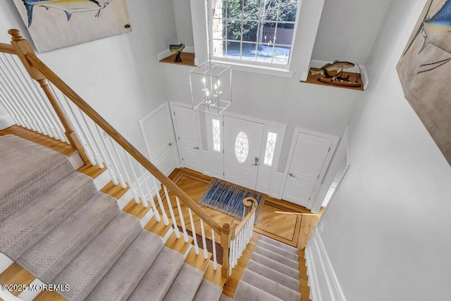 entryway with hardwood / wood-style flooring and a towering ceiling