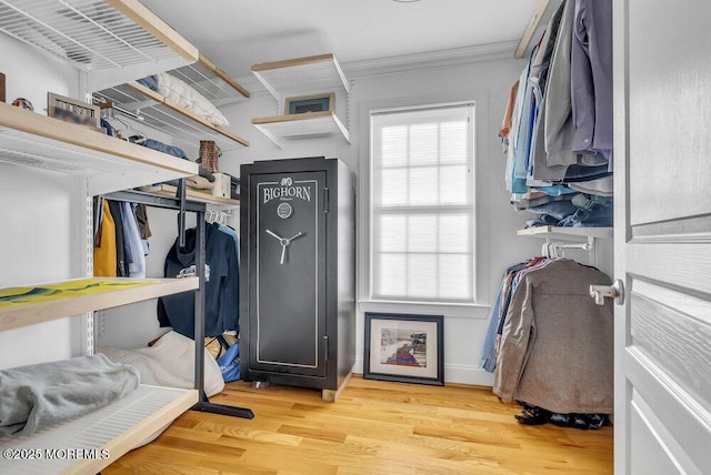 walk in closet with light hardwood / wood-style floors