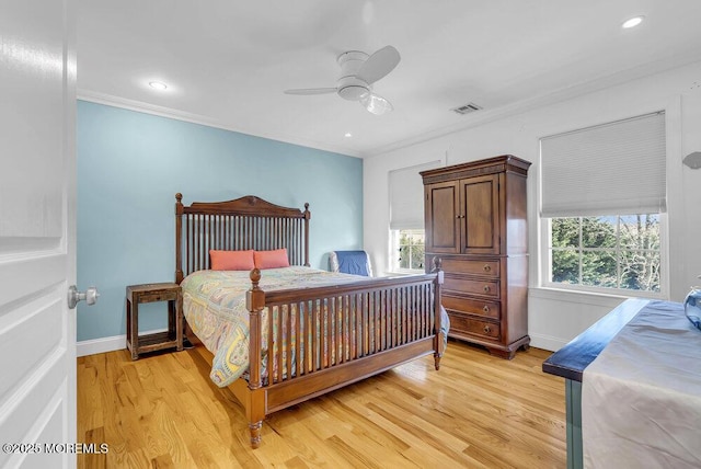 bedroom with ceiling fan, ornamental molding, multiple windows, and light wood-type flooring