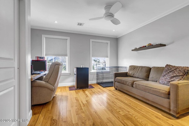 living room featuring crown molding, ceiling fan, and light hardwood / wood-style flooring