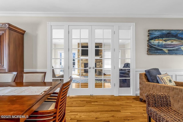 doorway with crown molding, light hardwood / wood-style flooring, and french doors