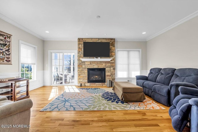 living room with hardwood / wood-style flooring, crown molding, and a fireplace