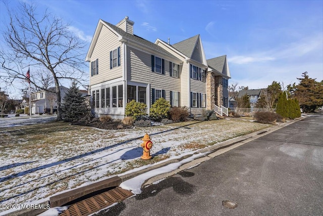 snow covered property featuring a sunroom