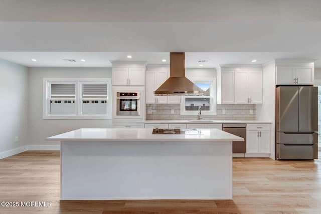 kitchen featuring sink, stainless steel appliances, white cabinetry, and exhaust hood