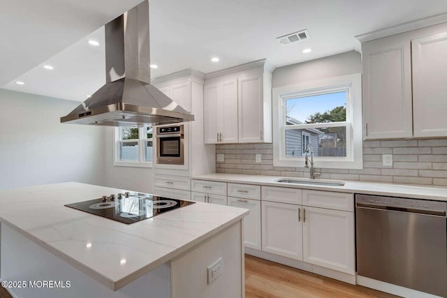 kitchen featuring white cabinets, appliances with stainless steel finishes, island range hood, and sink