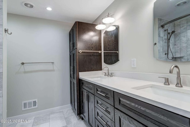 bathroom with vanity and tiled shower