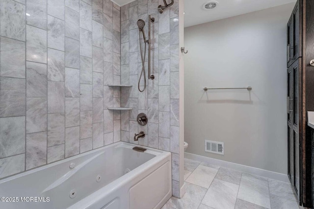 bathroom with tiled shower / bath combo and toilet