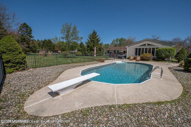 view of pool with a diving board and a patio area