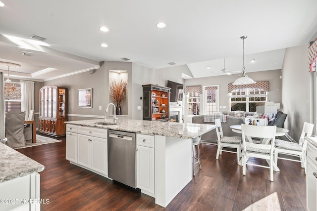 kitchen with decorative light fixtures, dishwasher, an island with sink, sink, and white cabinets