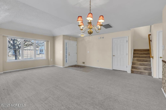 interior space featuring light colored carpet, a textured ceiling, and an inviting chandelier