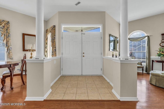 entrance foyer with light hardwood / wood-style floors and decorative columns