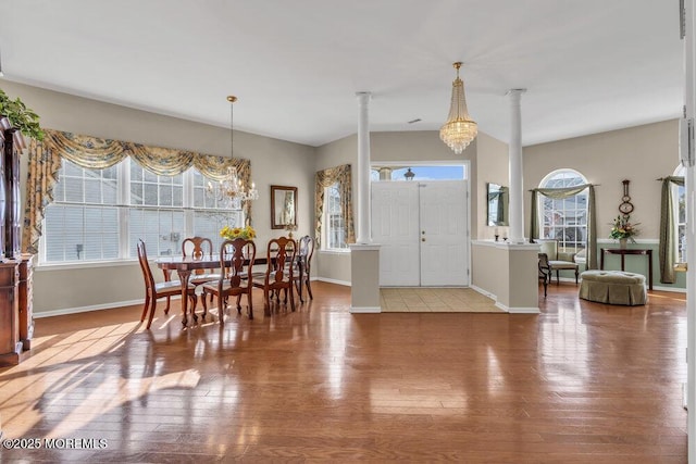 foyer with hardwood / wood-style flooring, a chandelier, and decorative columns