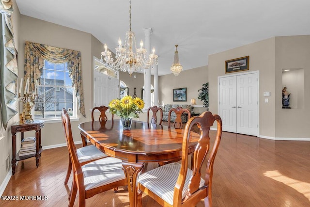 dining area with hardwood / wood-style flooring and an inviting chandelier