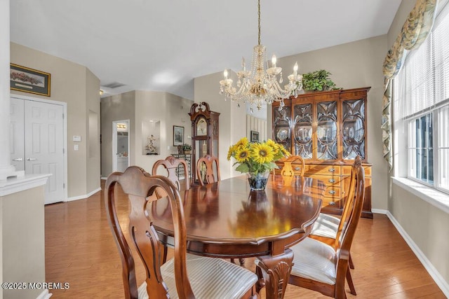 dining room with wood-type flooring and an inviting chandelier