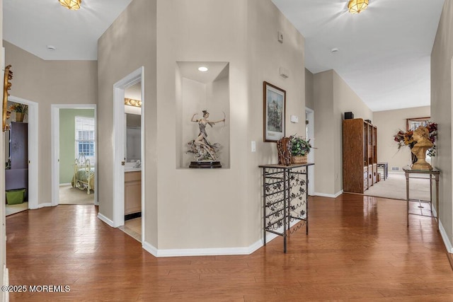 hallway with a high ceiling and wood-type flooring