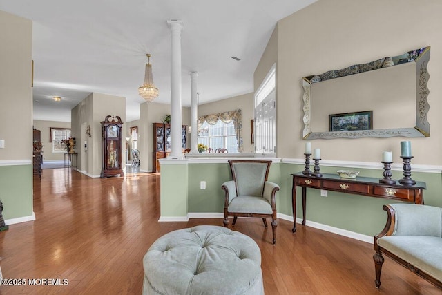 sitting room with ornate columns and hardwood / wood-style flooring