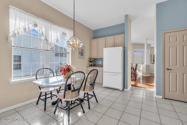 tiled dining room featuring an inviting chandelier