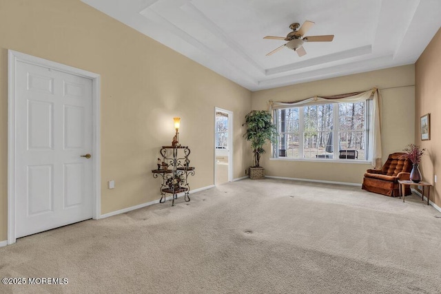 unfurnished room featuring light colored carpet, a raised ceiling, and ceiling fan