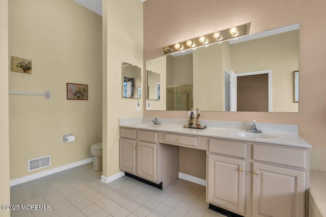 bathroom featuring vanity, tile patterned flooring, a shower with door, and toilet