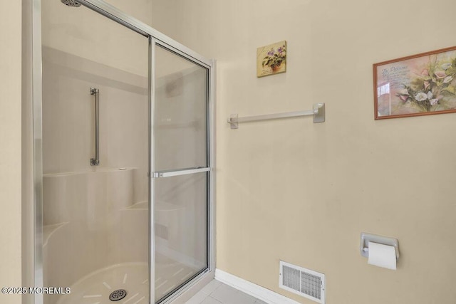 bathroom with an enclosed shower and tile patterned floors