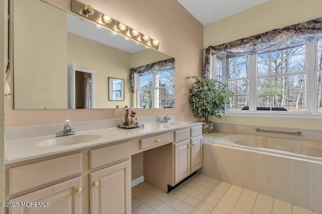 bathroom with vanity, tile patterned flooring, and tiled tub