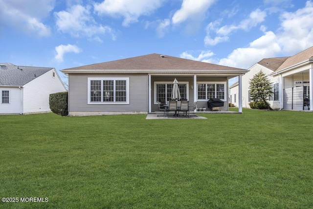 rear view of property with a patio and a lawn