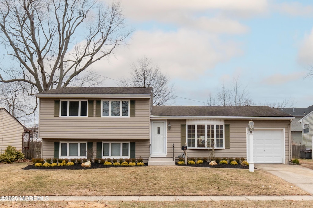 tri-level home featuring a garage and a front yard