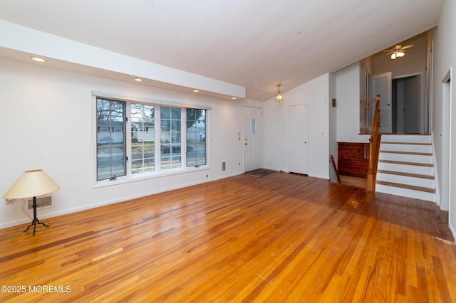 unfurnished living room with light wood-type flooring and lofted ceiling