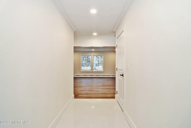 corridor with light tile patterned floors, crown molding, and baseboard heating