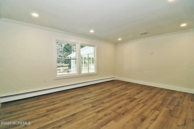 spare room featuring hardwood / wood-style floors, crown molding, and baseboard heating