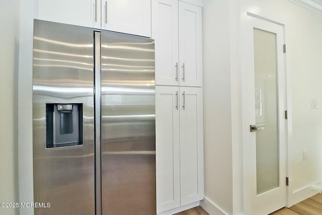 kitchen with stainless steel fridge with ice dispenser, light hardwood / wood-style flooring, and white cabinets