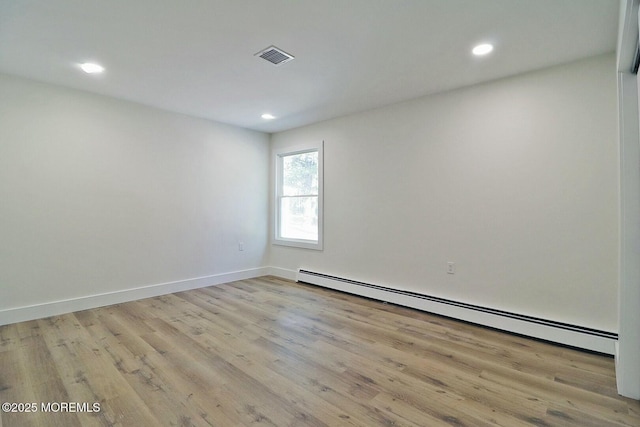 spare room featuring light hardwood / wood-style floors and a baseboard heating unit