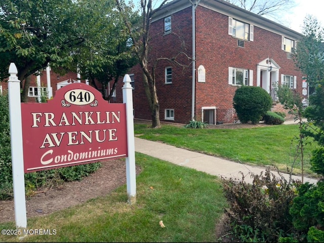 community / neighborhood sign featuring a yard