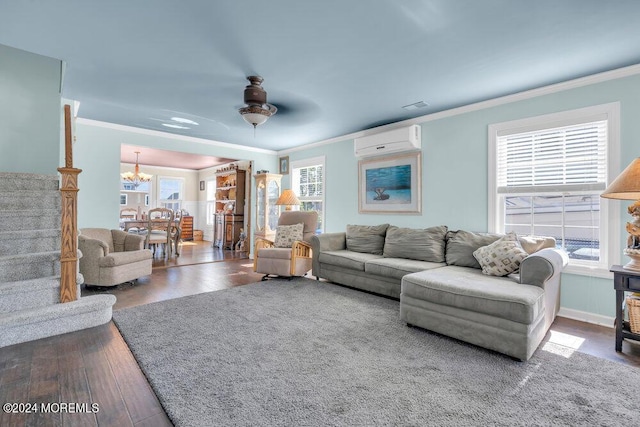 living room featuring hardwood / wood-style floors, ceiling fan with notable chandelier, an AC wall unit, and crown molding